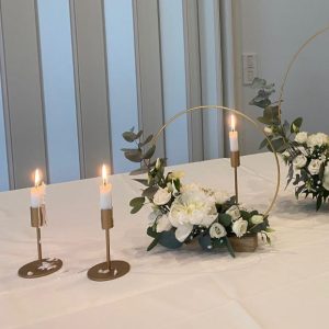 Vuokrattavat kultaiset kynttilänjalat.