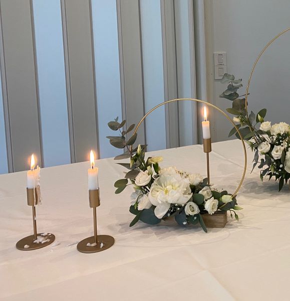 Vuokrattavat kultaiset kynttilänjalat.